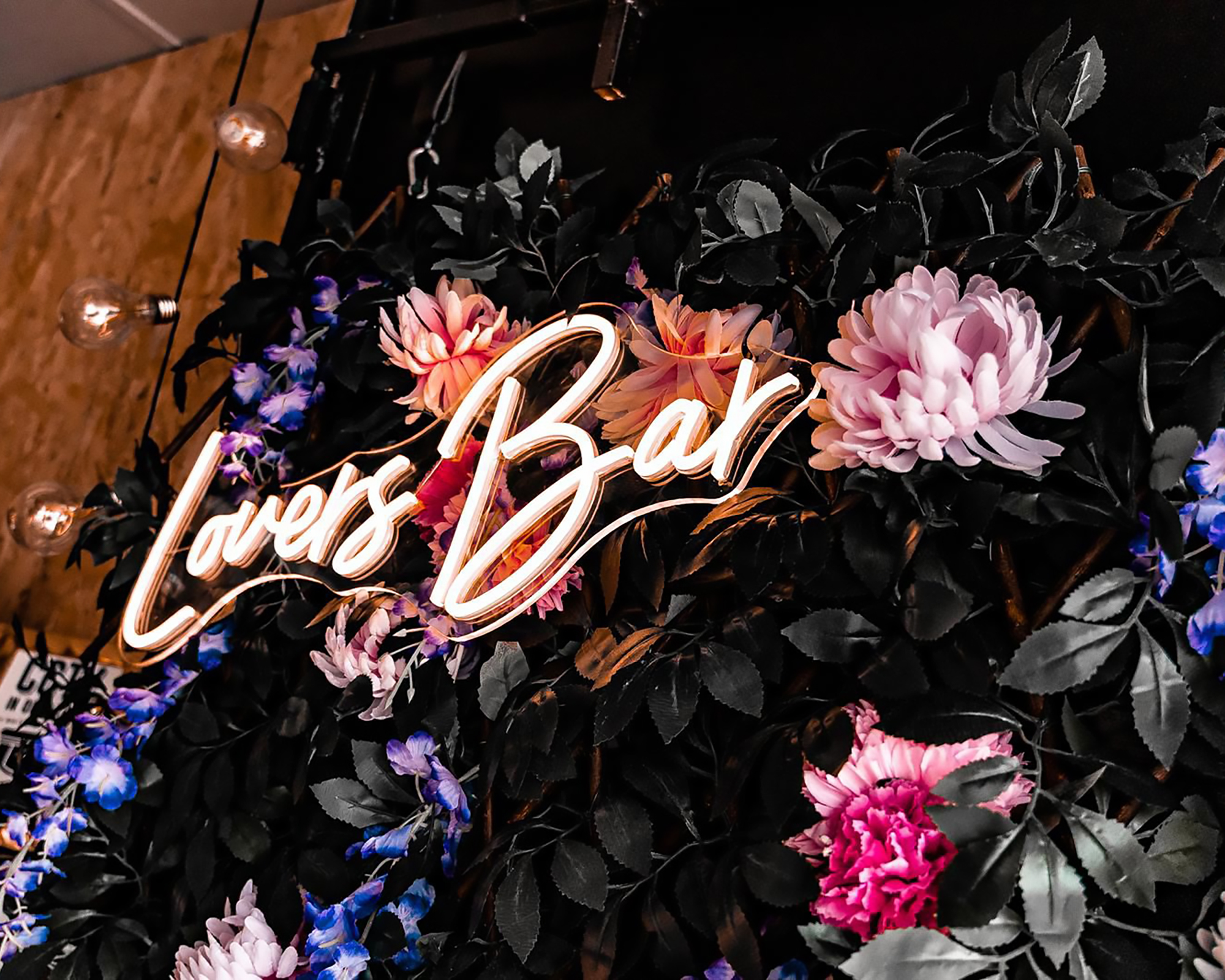 Lovers Bar light up sign on flower wall